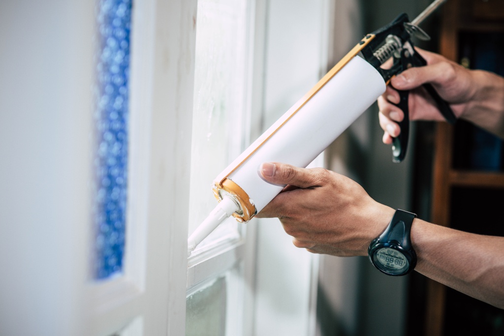 the-carpenter-holds-the-glue-and-attaches-to-the-window.jpg